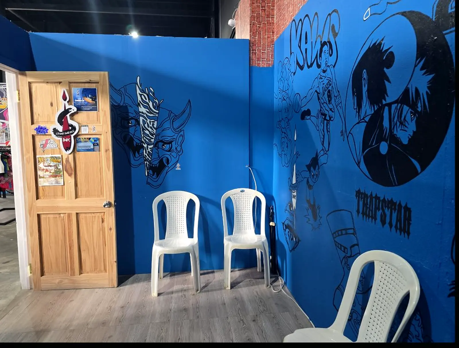 Waiting chairs beside the blue studio's hand-painted mural walls