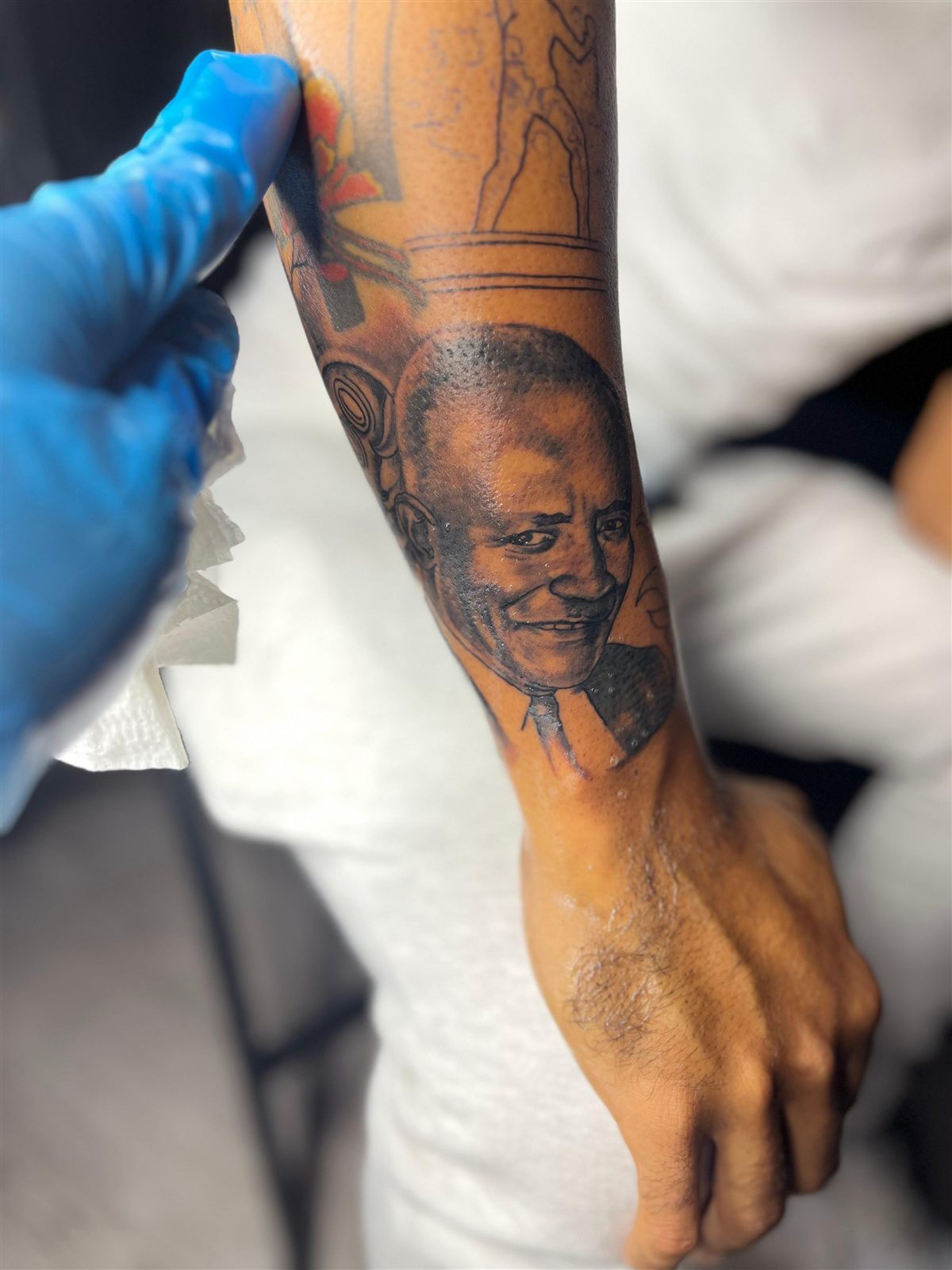 Portrait realism of a smiling man, black and grey, forearm