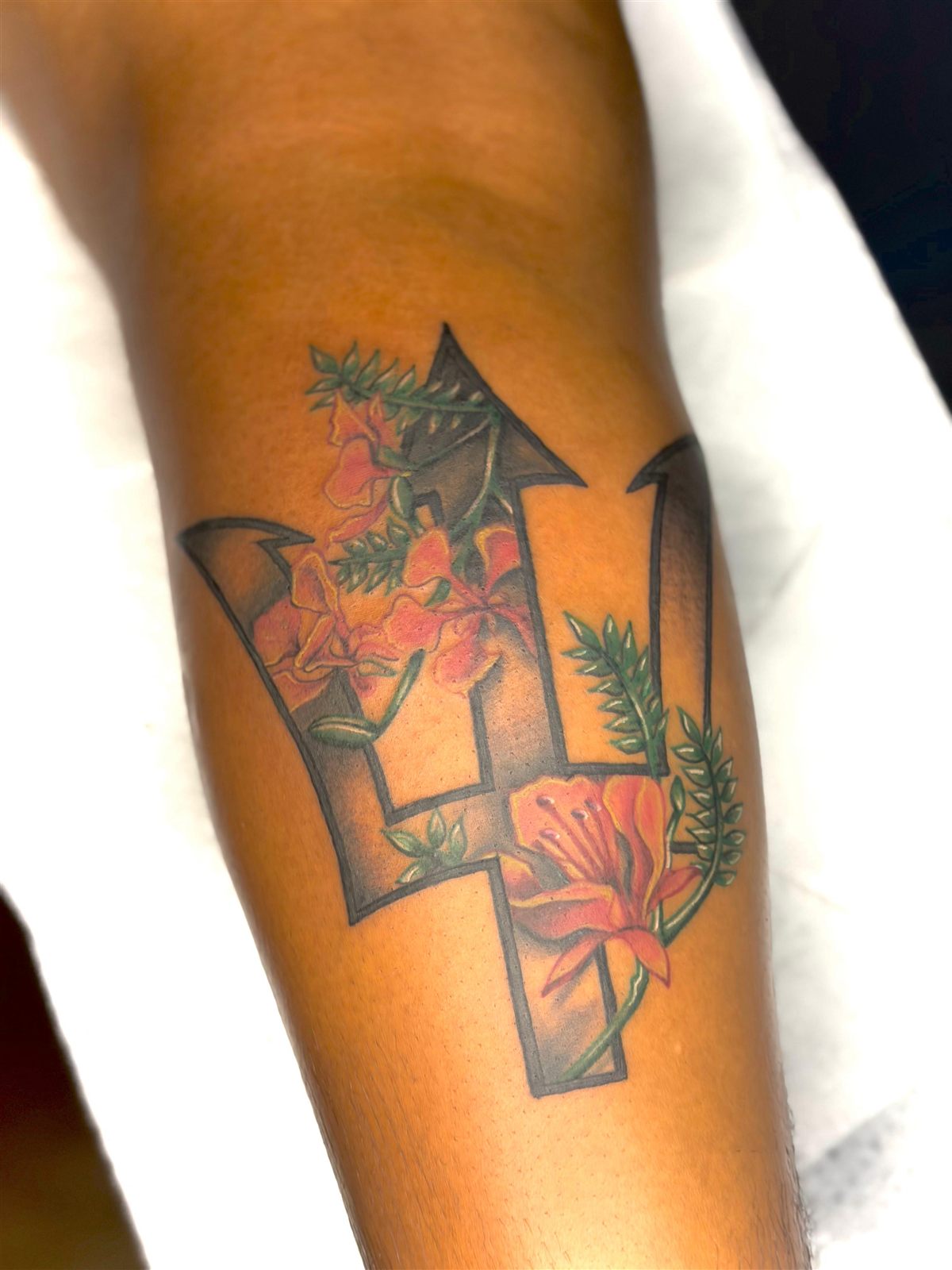Barbados trident filled with flamboyant flowers, colour, forearm